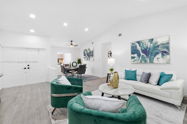 living area featuring wood finished floors, ceiling fan, vaulted ceiling, and visible vents