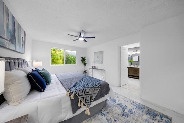 bedroom with marble finish floor, a textured ceiling, and a ceiling fan