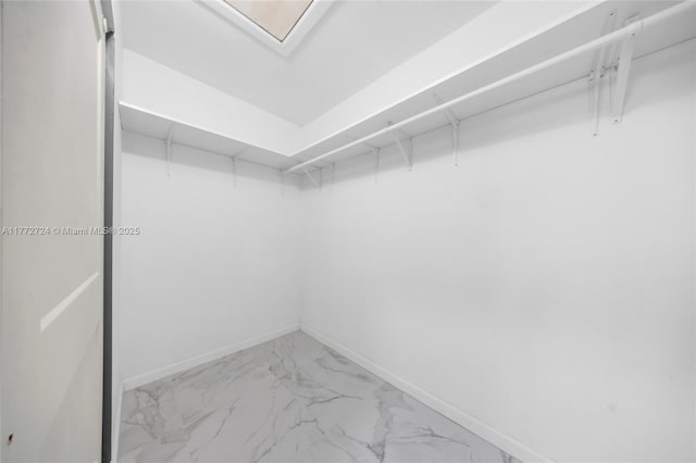 walk in closet with marble finish floor