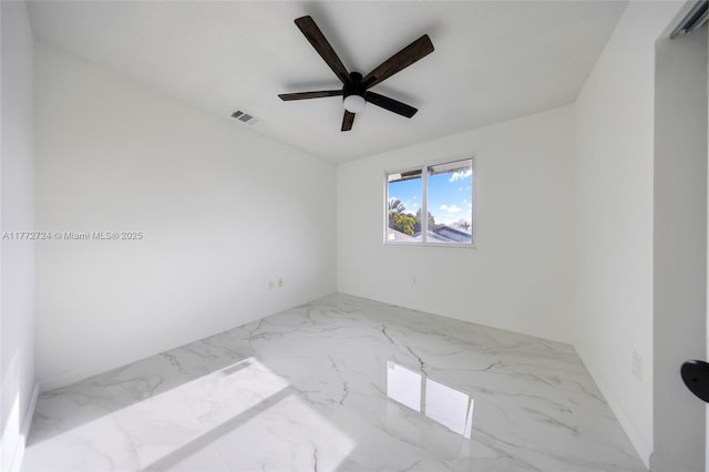 spare room featuring marble finish floor, ceiling fan, and visible vents