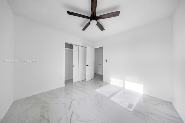 unfurnished bedroom featuring a closet, marble finish floor, and a ceiling fan