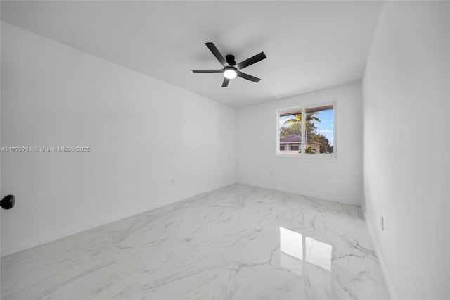 empty room featuring marble finish floor and a ceiling fan