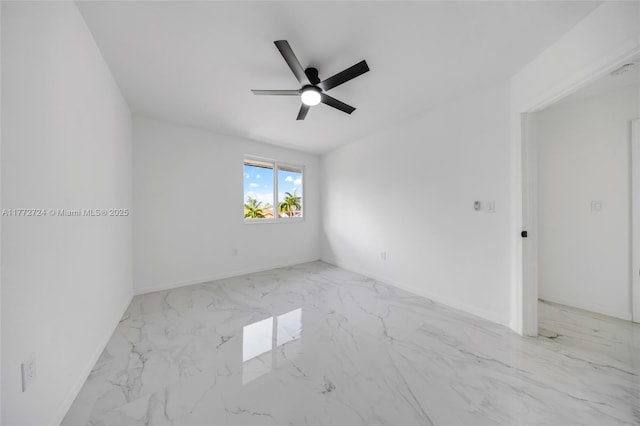 empty room featuring baseboards, marble finish floor, and ceiling fan