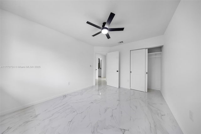 unfurnished bedroom featuring marble finish floor, visible vents, a closet, and ceiling fan