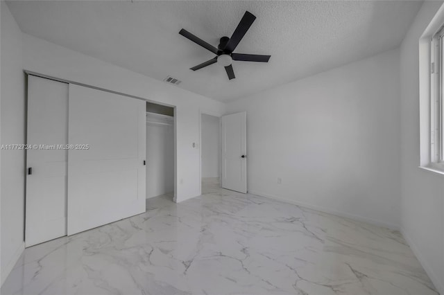 unfurnished bedroom featuring marble finish floor, visible vents, a closet, and a textured ceiling
