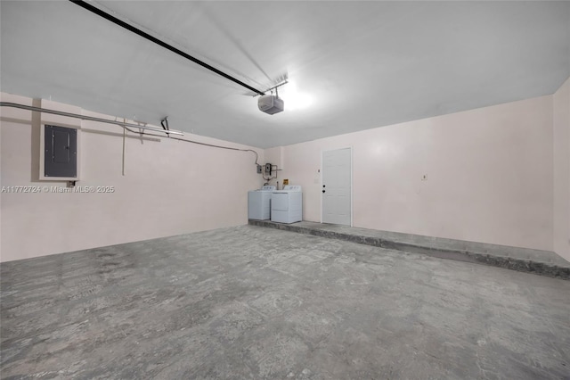 garage with washing machine and clothes dryer, a garage door opener, and electric panel
