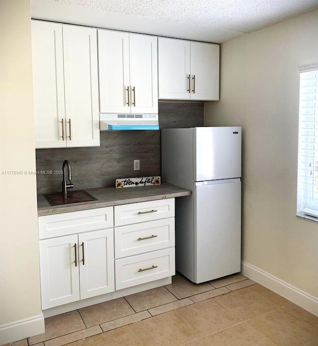 3190 NW 66th Dr, Fort Lauderdale, FL 33309 - kitchen featuring freestanding refrigerator, under cabinet range hood, a sink, tasteful backsplash, and baseboards