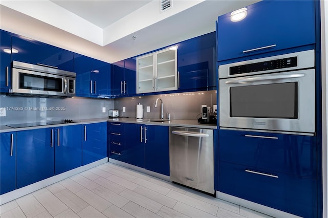 3101 Bayshore Dr Unit 603, Fort Lauderdale, FL 33304 - kitchen with stainless steel appliances, visible vents, blue cabinets, and decorative backsplash