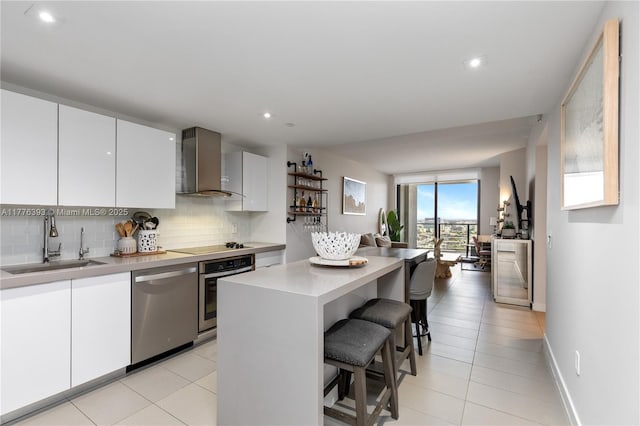 1600 NE 1st Ave Unit 2615, Miami, FL 33132 - kitchen with wall chimney range hood, a sink, appliances with stainless steel finishes, a kitchen breakfast bar, and tasteful backsplash