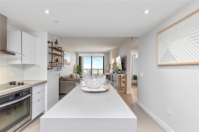 1600 NE 1st Ave Unit 2615, Miami, FL 33132 - kitchen featuring oven, wall chimney exhaust hood, light countertops, white cabinetry, and recessed lighting