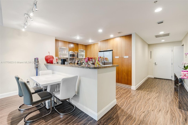 kitchen with baseboards, visible vents, stainless steel appliances, and a peninsula