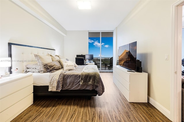 bedroom with expansive windows, access to exterior, wood finished floors, and baseboards