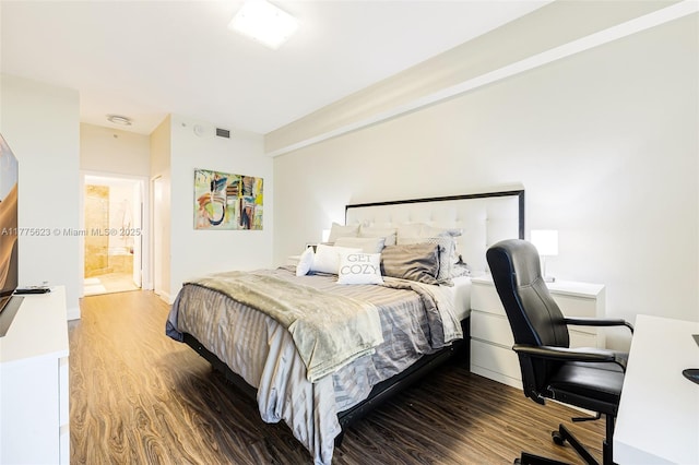 bedroom with baseboards, visible vents, wood finished floors, and ensuite bath