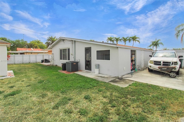 9215 SW 44th St, Miami, FL 33165 - back of house with central air condition unit, a lawn, fence, and stucco siding