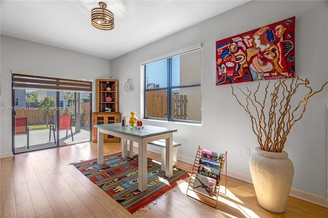 dining area with baseboards and wood finished floors