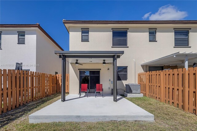 back of house featuring a patio area, central air condition unit, a ceiling fan, a fenced backyard, and stucco siding