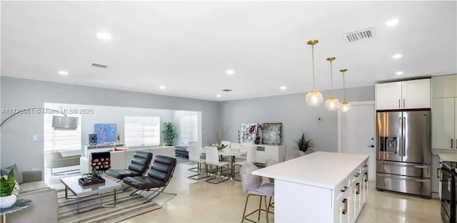 9380 SW 179th Ter, Palmetto Bay, FL 33157 - kitchen with stainless steel fridge, open floor plan, a breakfast bar area, light countertops, and a center island