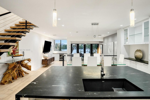 3543 S Ocean Blvd Unit 103, South Palm Beach, FL 33480 - kitchen with light wood finished floors, recessed lighting, white cabinetry, and hanging light fixtures
