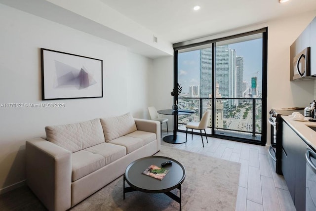 398 NE 5th St Unit 1408, Miami, FL 33132 - living area featuring light wood-type flooring, recessed lighting, a view of city, and a wall of windows