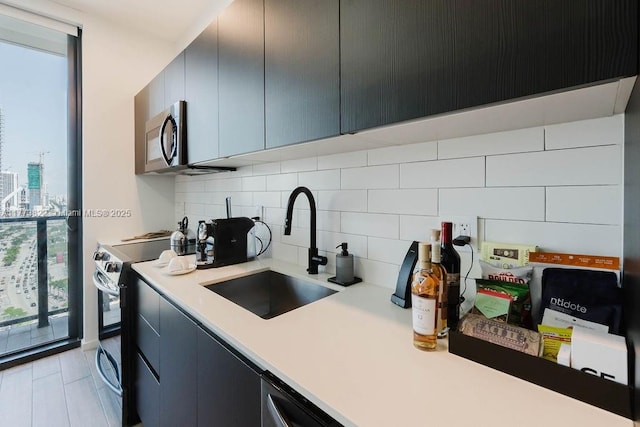 398 NE 5th St Unit 1408, Miami, FL 33132 - kitchen with light countertops, stainless steel microwave, decorative backsplash, black / electric stove, and a sink
