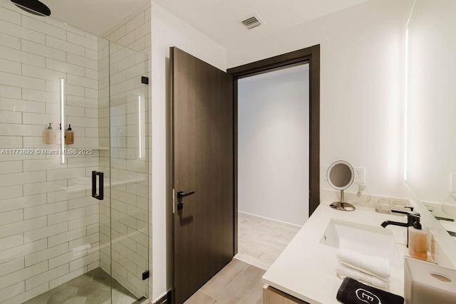 398 NE 5th St Unit 1408, Miami, FL 33132 - bathroom with a shower stall, a sink, visible vents, double vanity, and wood finished floors