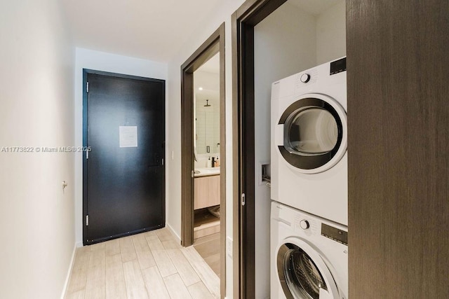 398 NE 5th St Unit 1408, Miami, FL 33132 - laundry room featuring baseboards, light wood-type flooring, stacked washer and clothes dryer, and laundry area