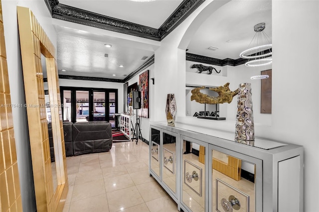 hallway featuring light tile patterned flooring, crown molding, french doors, visible vents, and arched walkways