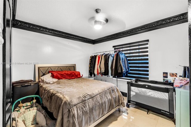 bedroom featuring light tile patterned floors and ornamental molding