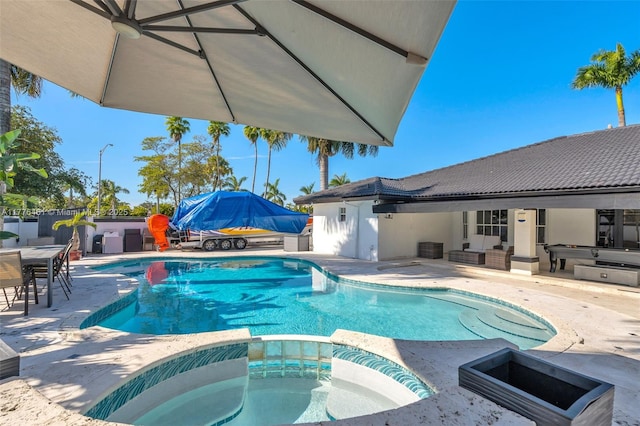view of pool featuring a pool with connected hot tub, a patio area, cooling unit, fence, and an outdoor hangout area