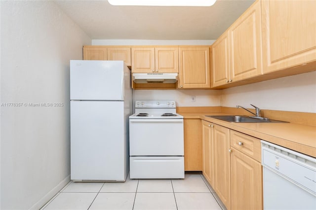 kitchen featuring white appliances, under cabinet range hood, and light brown cabinetry