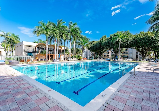 view of swimming pool featuring a patio area and fence