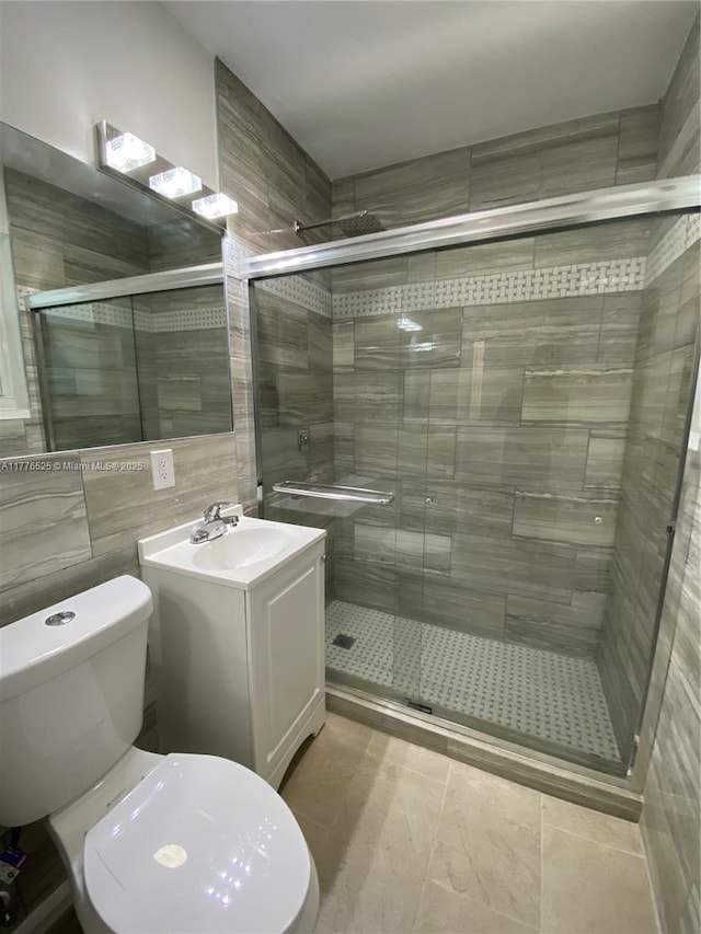bathroom featuring a shower stall, tile walls, toilet, and vanity