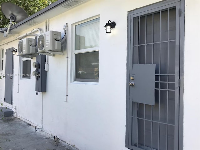 entrance to property featuring stucco siding and ac unit