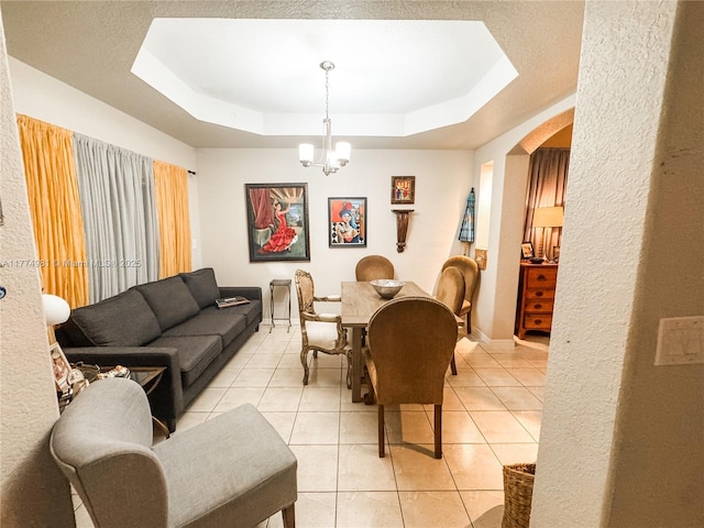 15809 SW 65th Ter, Miami, FL 33193 - dining area with baseboards, arched walkways, a tray ceiling, an inviting chandelier, and light tile patterned floors