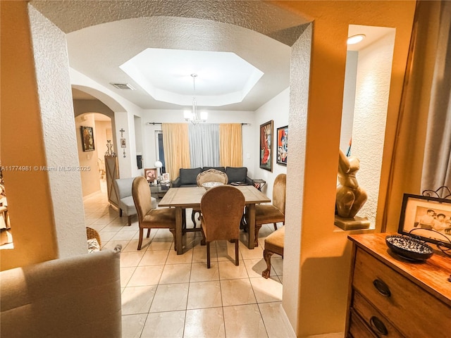 15809 SW 65th Ter, Miami, FL 33193 - dining area with visible vents, a notable chandelier, a raised ceiling, arched walkways, and light tile patterned floors