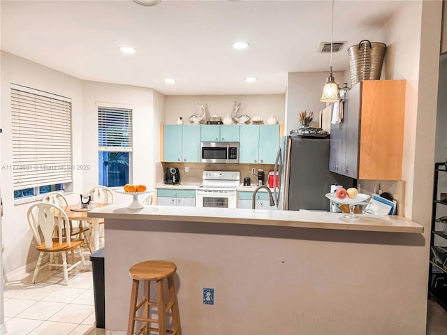 15809 SW 65th Ter, Miami, FL 33193 - kitchen featuring a peninsula, hanging light fixtures, stainless steel appliances, light tile patterned floors, and visible vents