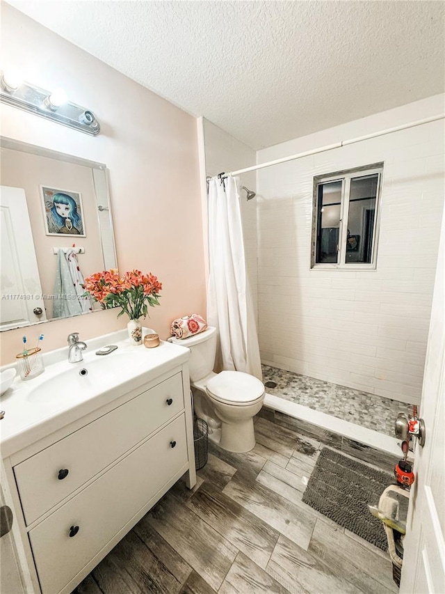 15809 SW 65th Ter, Miami, FL 33193 - bathroom with a tile shower, toilet, vanity, and a textured ceiling