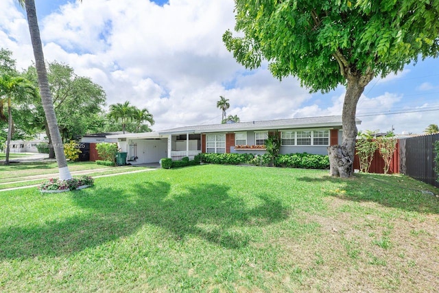 ranch-style house featuring a front lawn and fence