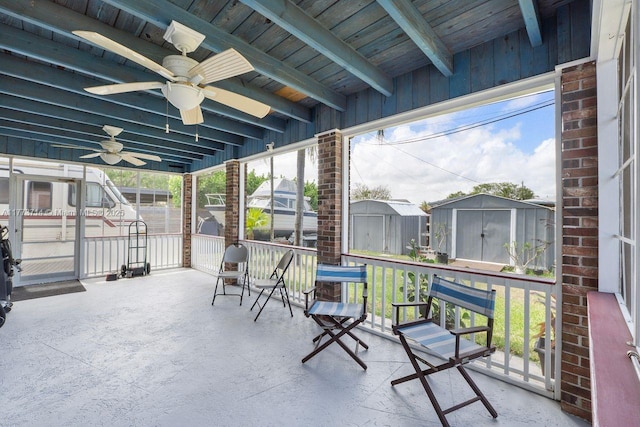 view of patio featuring a storage unit, a ceiling fan, and an outbuilding