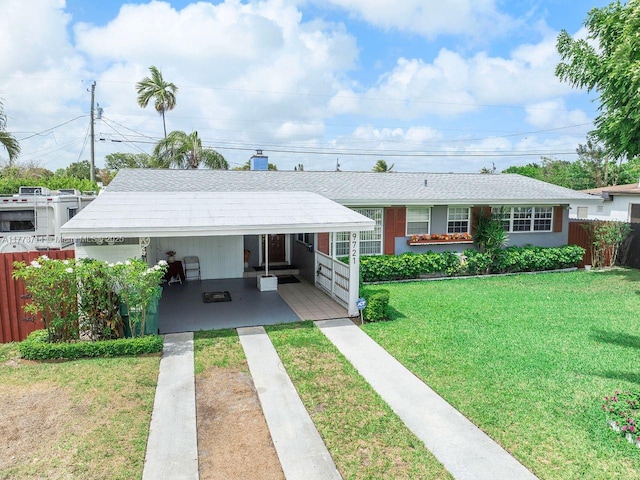 single story home with fence, a carport, concrete driveway, and a front lawn