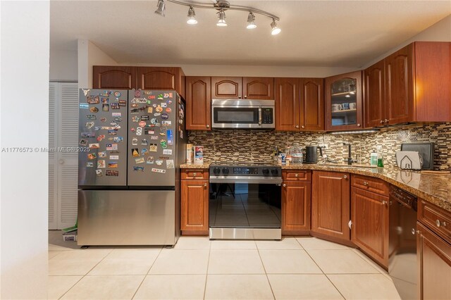 1680 NE 191st St Unit 307-2, Miami, FL 33179 - kitchen with stainless steel appliances, a sink, tasteful backsplash, light tile patterned floors, and glass insert cabinets