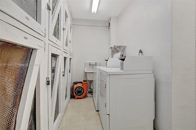 3111 N Ocean Dr Unit 308, Hollywood, FL 33019 - laundry area with light tile patterned flooring, washing machine and dryer, and cabinet space