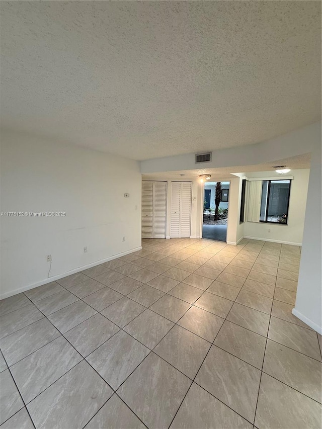 8335 SW 152nd Ave Unit B-106, Miami, FL 33193 - unfurnished room featuring a textured ceiling and light tile patterned flooring