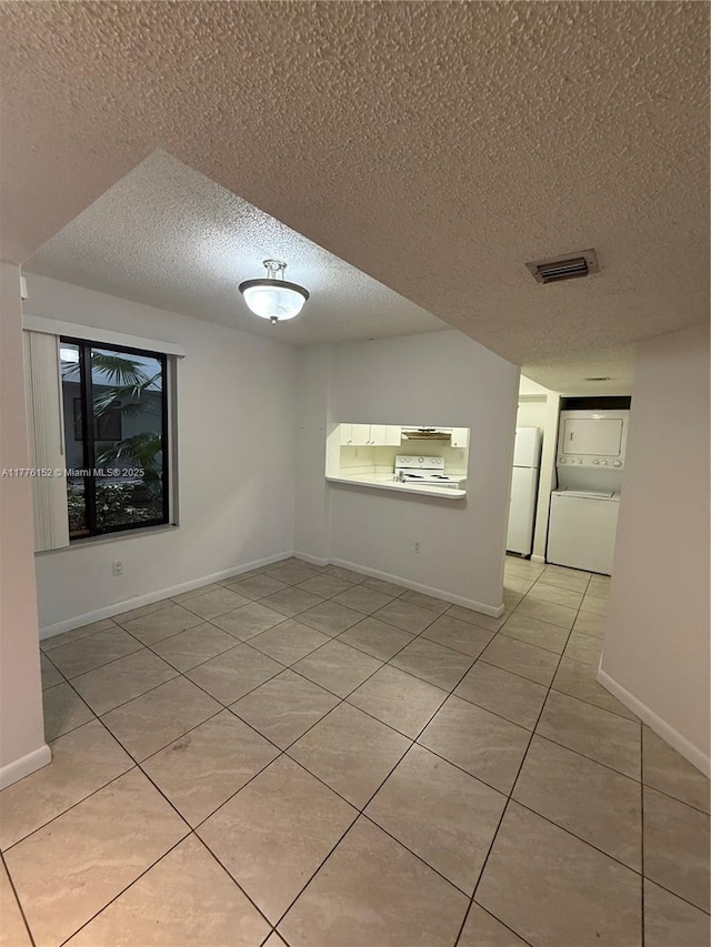 8335 SW 152nd Ave Unit B-106, Miami, FL 33193 - unfurnished room with stacked washer / dryer, a textured ceiling, and light tile patterned flooring