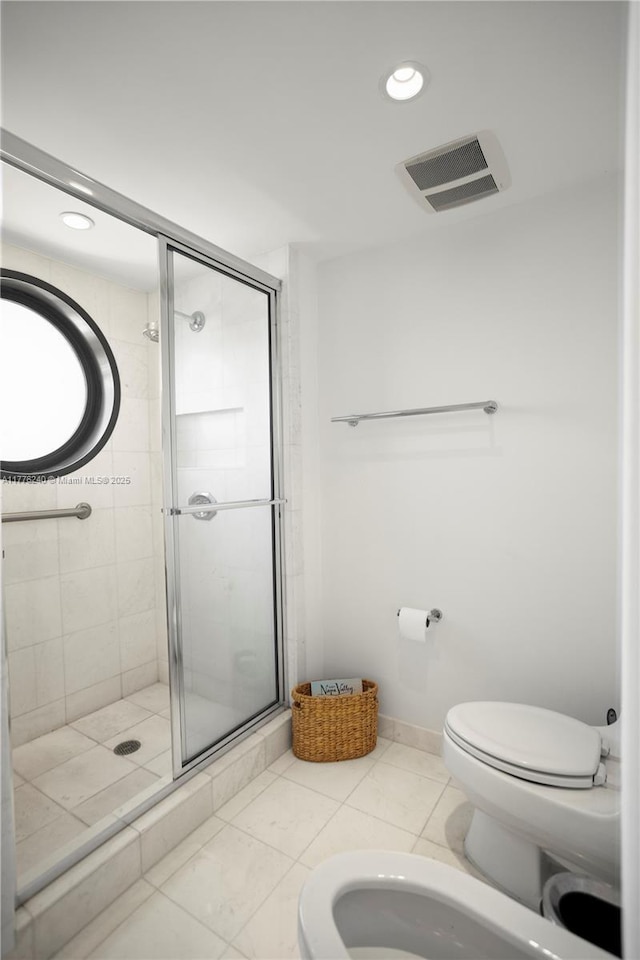 bathroom with a stall shower, visible vents, a bidet, and toilet