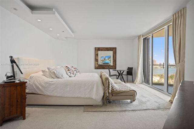 carpeted bedroom with a wall of windows, recessed lighting, and access to outside