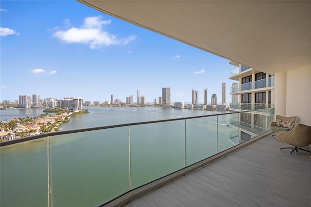 balcony with a water view and a view of city