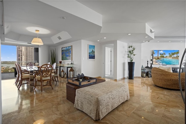 living area with marble finish floor, visible vents, recessed lighting, and a raised ceiling