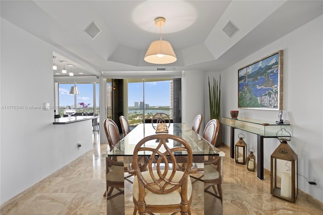 dining area with marble finish floor, visible vents, and a raised ceiling