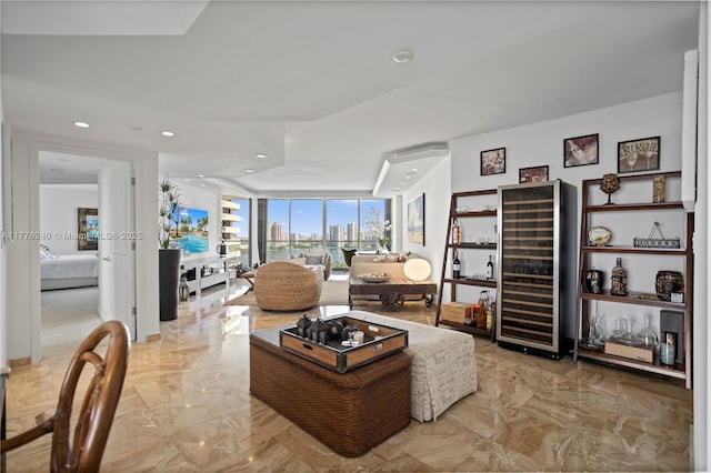 living room with a wall of windows, marble finish floor, wine cooler, recessed lighting, and a view of city